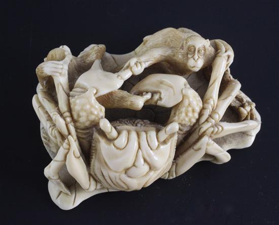 A Japanese marine ivory okimono of a crab battling two monkeys, early 20th century, 7cm